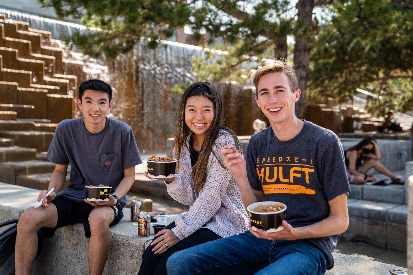 undergraduate students eating by fountain